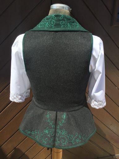 Dunkelgraue Weste mit grünem Kragen und weißen Ärmeln, eleganter Schnitt.